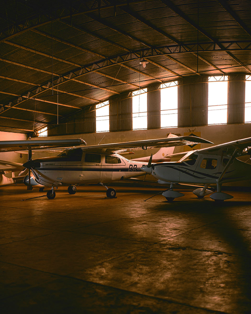 Small planes shown in a steel hangar